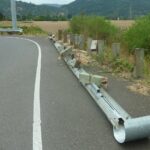 A damaged crash barrier along a roadway