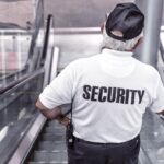 A security guard riding down an escalator
