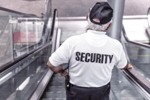 A security guard riding down an escalator