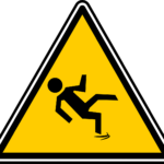 a warning sign depicting a slippery floor